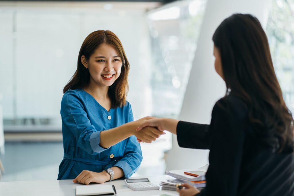 An applicant shaking hands with her first job interviewer.
